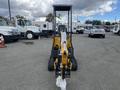 A yellow 2024 AGT Mini Excavator facing forward with a wrapped arm and tracks resting on a paved surface