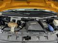 A 2015 Chevrolet Express engine compartment showing various components like the air intake, battery, and coolant reservoir