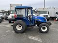 A blue 2007 New Holland TN70A tractor with a transparent canopy and large rear tires shown from the side