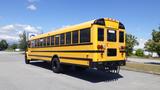 A yellow 2014 International 3000 school bus with black accents viewed from the rear showing its large windows and distinct back lights