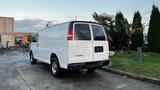 A white 2005 Chevrolet Express van is parked with its rear visible showcasing its clean lines and dual rear doors