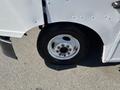 A close-up view of a white 2007 Ford Econoline tire and wheel assembly with visible lug nuts and a black tire