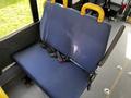 A blue fabric bus seat with a seatbelt and yellow armrests in a transit vehicle interior