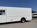 A white 2011 Ford Econoline van with a large blank cargo area on the side and single rear wheels