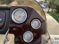 The image shows the dashboard of a 2013 Sylvan boat featuring three circular gauges for fuel trim and RPM with a wood finish panel