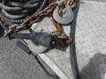 A close-up of a 2010 Forest River Enclosed trailer's connector and chains with a coiled cable in the background