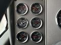 A panel showing six gauges from a 2014 Kenworth T370 indicating volts, water temperature, and various air pressure levels for braking and suspension systems