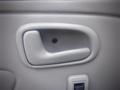 Interior door handle of a 2003 Toyota Toyoace in a light gray finish with a smooth texture and a visible screw in the center