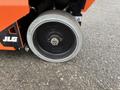 A close-up view of a wheel from a 2024 JLG R1932 featuring a black metal rim and a silver tire with visible tread patterns