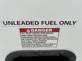 A sign on a vehicle indicating unleaded fuel only with a warning about turning off pilot lights and appliances during refueling to prevent serious injury or death