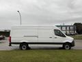A 2019 Mercedes-Benz Sprinter van in white with a high roof and side sliding door parked on a grassy area