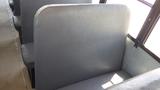 Interior view of a 2014 International 3000 school bus showing gray vinyl seats arranged in a row with a focus on the backrest of one seat