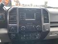 Interior dashboard of a 2017 Ford F-150 featuring a central display screen and control knobs for audio and climate settings