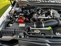 The image shows the engine compartment of a 2021 Ford F-550 featuring various components including the battery air intake and several hoses and cables