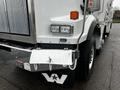 A 2011 Western Star Trucks 4900 with a chrome front grille two headlights and a diamond plate step at the front featuring a logo with a star and the letter W