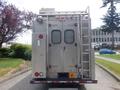 A silver 2007 Morgan Olson Workhorse W42 with a ladder on the side and various lights mounted on the top and rear doors featuring mesh coverings