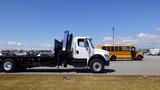 A 2017 Freightliner M2 106 flatbed truck with a white cab and a black chassis parked on a lot