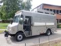 A silver 2007 Morgan Olson Workhorse W42 food truck with multiple large storage tubes on the roof and a driver's seat visible inside the open side door