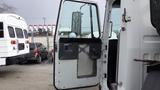 The image shows the open driver side door of a 2007 Autocar WXLL truck with a metal panel and a window frame