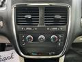 A 2011 Dodge Grand Caravan dashboard control panel featuring air conditioning and heating dials as well as airflow direction buttons