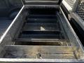 A 2017 Ford F-150 truck bed with a diamond plate toolbox opened revealing two empty trays inside