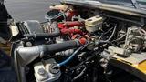 Engine compartment of a 2014 Freightliner Thomas Diesel bus featuring red and black engine components hoses and fluid reservoirs