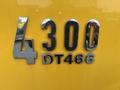 Chrome number 4300 with the letters DT466 on a bright yellow surface