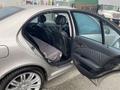 A 2007 Mercedes-Benz E-Class with an open back door revealing the interior and seats with a gray cover on the back seat