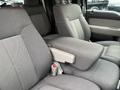 Two gray upholstered front seats of a 2010 Ford F-150 with a center console between them