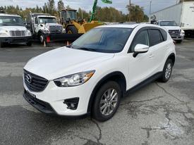 A white 2016 Mazda CX-5 parked with a modern design featuring a sleek front grille and alloy wheels