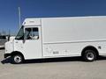 A white 2011 Ford Econoline delivery van with a boxy shape and large side windows