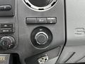 Dashboard controls of a 2011 Ford F-250 SD featuring climate controls a power button and a 12V power outlet knob