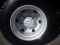 A silver wheel rim with six bolts and a circular hub attached to a black tire designed for a 2013 Mitsubishi Fuso FE 160