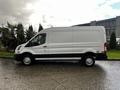 A white 2020 Ford Transit van is displayed from the side, featuring a high roof and large cargo area with a black stripe along the bottom and silver wheels