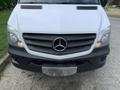 Front view of a white 2017 Mercedes-Benz Sprinter van featuring a prominent Mercedes-Benz emblem and distinct horizontal grille design