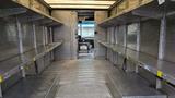 Interior of a 2006 Ford Econoline with metal shelves on both sides and a flat floor designed for carrying cargo