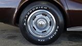 A close-up of a 1971 Chevrolet Corvette Stingray wheel featuring a chrome rim and a black tire with white lettering B.F.Goodrich Radial TA