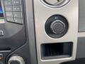 Interior panel of a 2013 Ford F-150 featuring knobs for climate control and a 12V power outlet