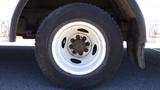 A close-up of a white wheel and tire from a 2006 Ford Econoline showing the rim and lug nuts