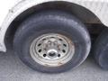 A close-up of a rusted wheel of a 2010 Forest River Enclosed trailer featuring a silver rim and a black tire with visible tread patterns