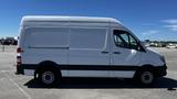 A 2016 Mercedes-Benz Sprinter van in white with a high roof and sliding side door, parked with its passenger side facing the viewer