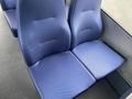 A pair of blue textured seats designed for a bus interior with a sleek and modern appearance