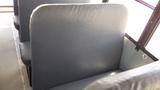 Interior view of a bus seat in a 2014 International 3000 with grey padding and a simple design