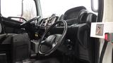 Interior of a 2009 Hino 338 garbage truck showing the driver's seat dashboard and steering wheel