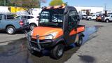 A 2013 Kubota RTV 1100 utility vehicle with orange and black exterior featuring a cab and a cargo bed in the back