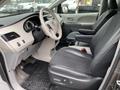 Interior of a 2013 Toyota Sienna showing front seats dashboard and center console with various controls and storage compartments