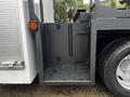 Close-up of a gray utility compartment on a 2005 Freightliner M2 106 with two hooks and a textured floor