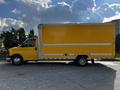 A yellow 2017 GMC Savana box truck parked on the street with a smooth body and large cargo area