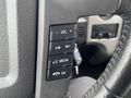 Close-up of the steering wheel controls of a 2013 Ford F-150 featuring buttons for volume media and phone functions