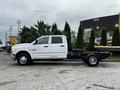 A white 2018 RAM 3500 chassis cab with a spacious crew cab design and a flatbed, ready for construction or utility use